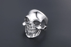 Détails macro d'une bague crâne punk montrant les dents et la finition acier poli