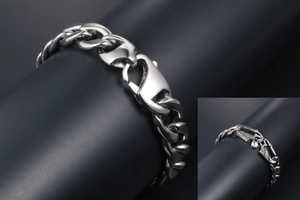 Gros plan d'un bracelet gourmette rétro en acier titane avec crâne et ailes