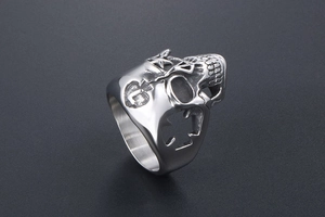 Detailed view of hollow star and cross patterns on a skull ring's polished steel band