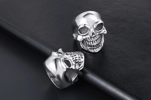 Vue détaillée de deux bagues tête de mort style gothique punk sur fond en cuir noir