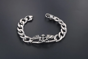 Vue détaillée du crâne avec ailes sur le bracelet gourmette en acier titane style punk