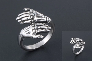 Close-up of vintage stainless steel punk ring showing detailed realistic hugging hands
