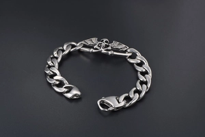 Détail du crâne et des ailes en relief sur un bracelet gourmette punk en acier inoxydable