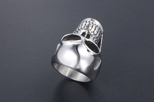 Macro view of polished silver skull ring featuring intricate scale textures and punk design
