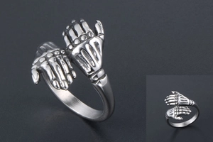 Detail view of double skeleton hands embrace ring in vintage steel finish with Gothic style