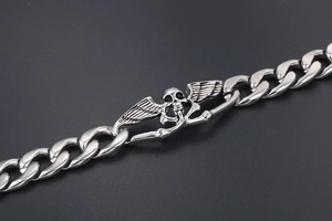 Détail du crâne rétro avec ailes sur un bracelet gourmette massif en acier inoxydable