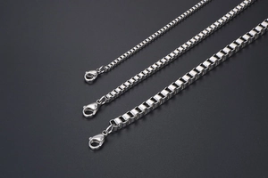 Detailed view of three stainless steel box chains in different thicknesses with lobster clasps