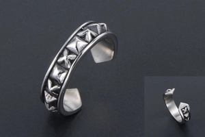 Detailed macro view of vintage silver ring with geometric relief and punk style spikes