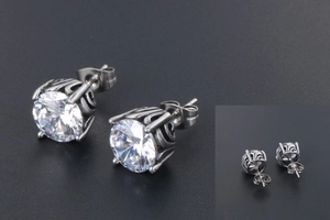 Macro view of vintage silver stud earrings with six-prong set cubic zirconia and filigree