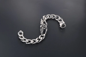 Détail du bracelet gourmette vintage en acier titane argenté avec crâne et ailes