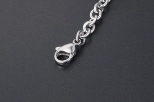 Detailaufnahme einer silbernen Metallkette mit poliertem Karabinerverschluss auf grauem Grund