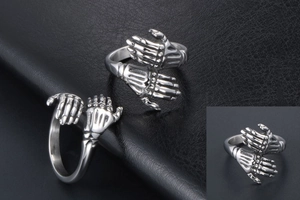 Detail view of vintage punk style silver metal double skeleton hand hug ring on leather