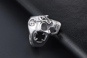 Macro shot of silver gothic skull ring with star relief and hollow cross detail