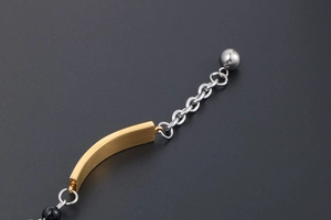 Macro shot of gold brushed metal component and silver chain detail of the bracelet