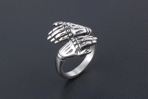 Detail of vintage punk mechanical skeletal hand ring with black aged finish texture