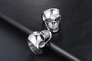 Detailed view of two punk skull rings with intricate gothic engravings on leather