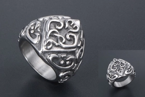 Macro shot of vintage embossed floral patterns on a heavy punk-style stainless steel ring