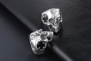 Macro detail of silver stainless steel skull ring with side hollow cross engravings
