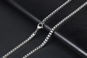 Close-up of a silver stainless steel box chain necklace with a secure lobster clasp