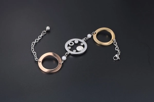 Details eines dreifarbigen Metallarmbands mit Strasssteinen und weißen Perlenakzenten