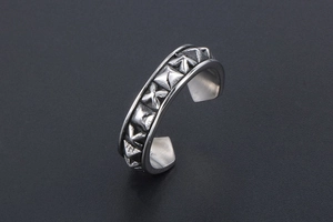 Detail of vintage oxidized silver open ring with 3D pyramid and cross star engraving