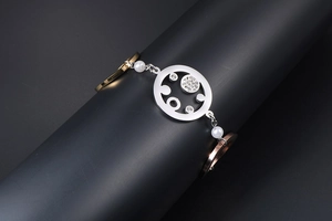 Detailaufnahme eines dreifarbigen Metallarmbands mit Strasssteinen und Perlen