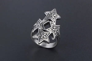 Macro shot of silver titanium steel ring with layered stars and radial textures