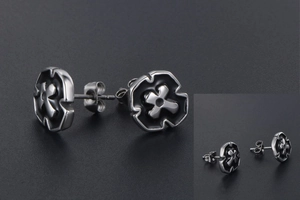 Macro shot of silver stainless steel cross stud earring with black enamel details