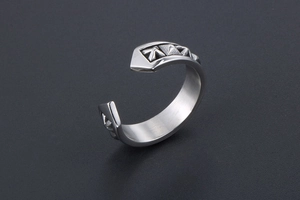 Macro detail of retro engraved patterns on the open silver-tone ring with industrial finish