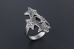 Detail view of overlapping silver star rings with vintage embossed texture in punk style