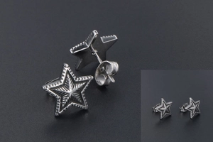 Macro view of vintage titanium steel star earrings with detailed radial engravings