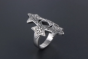 Macro detail of overlapping silver stars on a textured titanium steel band for men