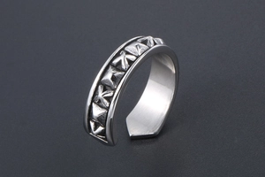 Detail of vintage embossed geometric patterns on an adjustable silver open ring