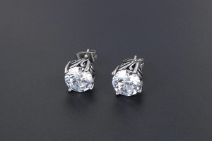 Detail of vintage silver earrings with bright zircon stones and filigree metal patterns
