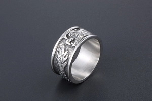 Détail macro d'une bague dragon vintage montrant des motifs de plumes gravés