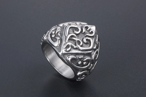 Detailed close-up of retro titanium steel ring with embossed floral and heart patterns