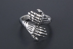 Close-up of vintage punk stainless steel ring featuring detailed twin skull hand design