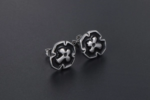 Macro detail of gothic cross earrings in titanium steel with black enamel finish
