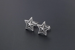 Macro view of retro star-shaped titanium steel studs with radial textures and wavy edges