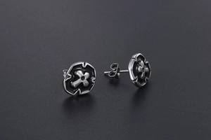 Detailed macro view of cross-pendant hoop earrings with vintage black oxidation finish
