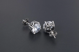 Detail of vintage silver earrings with hollow pattern and clear cubic zirconia stones
