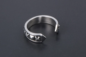 Detail of vintage carved open ring with pyramid stud texture in steel finish