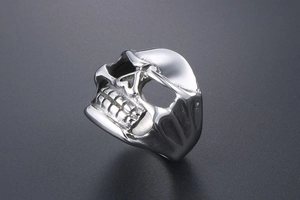 Close-up of vintage stainless steel skull ring with punk style carved teeth details