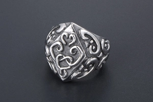 Macro view of vintage stainless steel ring with intricate baroque relief patterns
