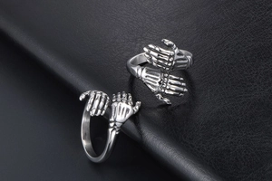Close-up of vintage punk rings featuring detailed skeletal hand wrap design in steel