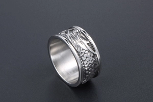 Détail macro d'une bague dragon vintage en acier montrant les écailles gravées