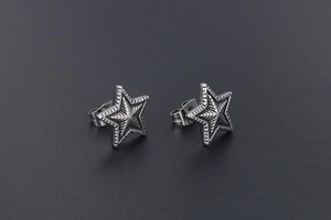 Macro detail of industrial vintage star stud earrings in silver titanium steel