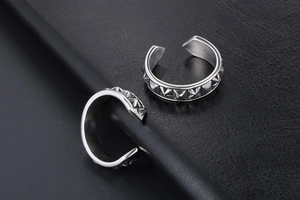 Macro detail of punk style open rings featuring silver pyramid studs on leather