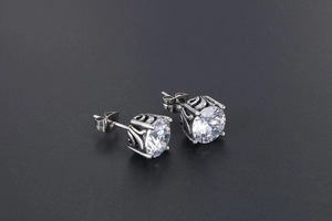 Macro view of crystal stud earrings with vintage filigree details and butterfly backings