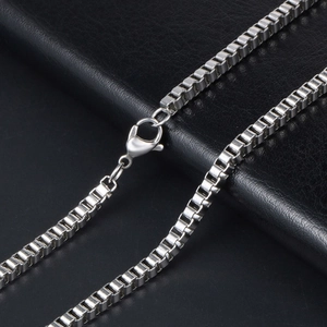 Polished silver stainless steel box chain necklace with lobster clasp on black background